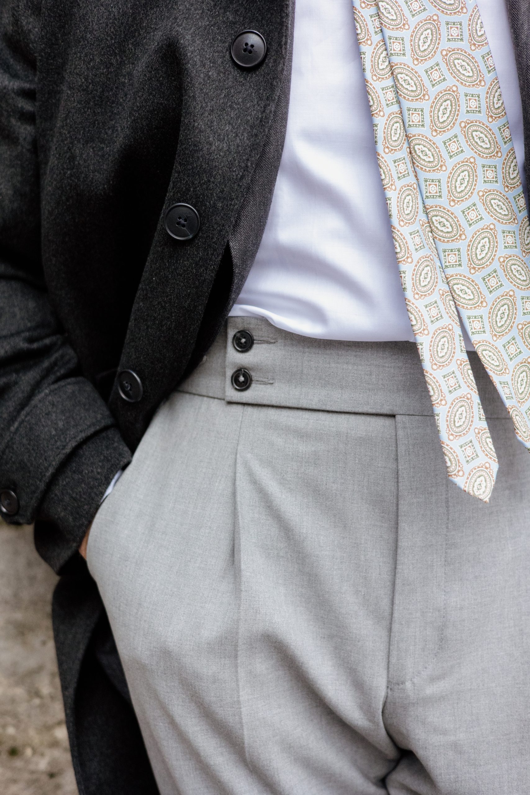 image descriptive d'un pantalon gris et, d'une cravate et d'un manteau.